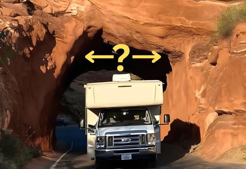 Class C RV Driving Out of a Narrow Tunnel Carved Through a Large Rock Formation, Yellow Question Mark and Arrows Question Whether the Tunnel is Wide Enough for the RV