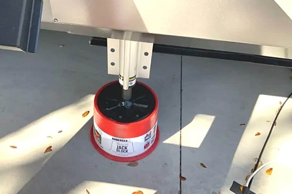 Close-up of a RV Leveling Jack Extended and Resting on a Red Jack Block