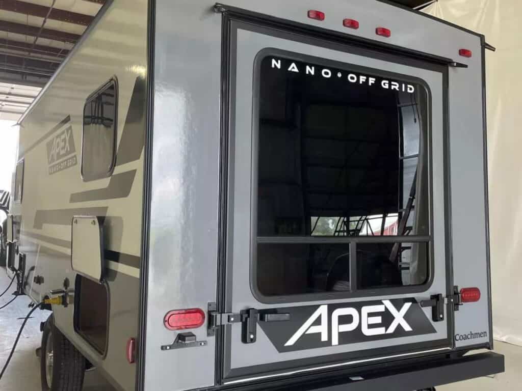 Rear exterior view of a Coachmen Apex Nano 17TH toy hauler with a closed rear hatch with a large window.